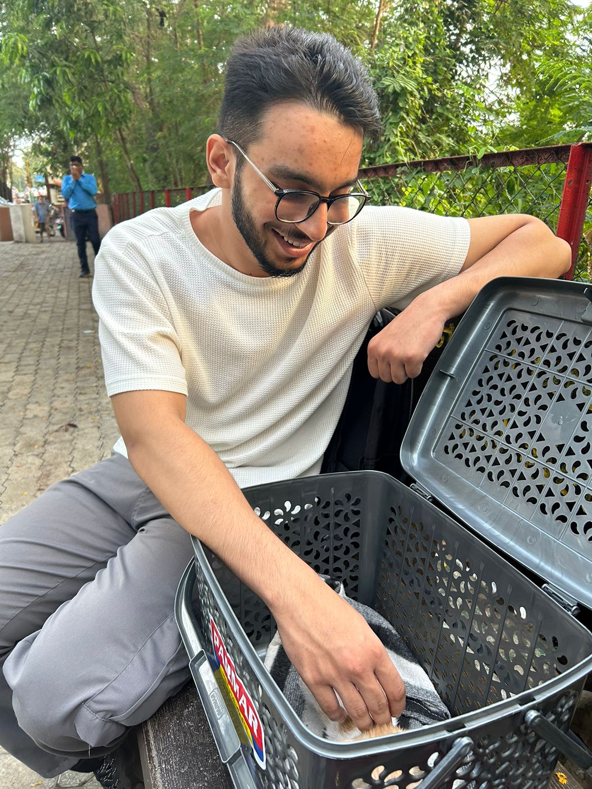 Aadil smiling down at Billu inside the carrier